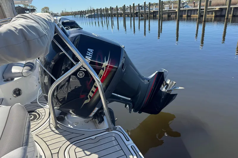 Slide: The Image of 2019 Hurricane SunDeck 2486 OB with Yamaha outboard motor docked by calm waters. - 14