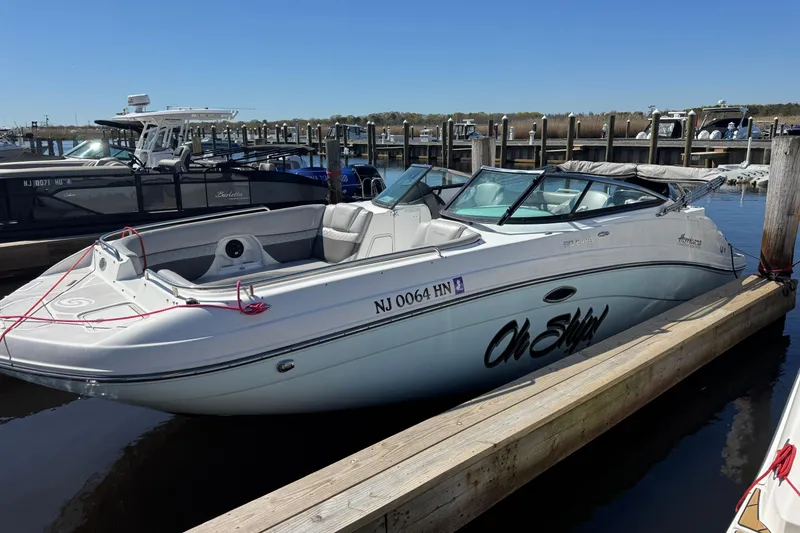 Slide: The Image of 2019 Hurricane SunDeck 2486 OB boat docked at marina, clear sky background. - 2
