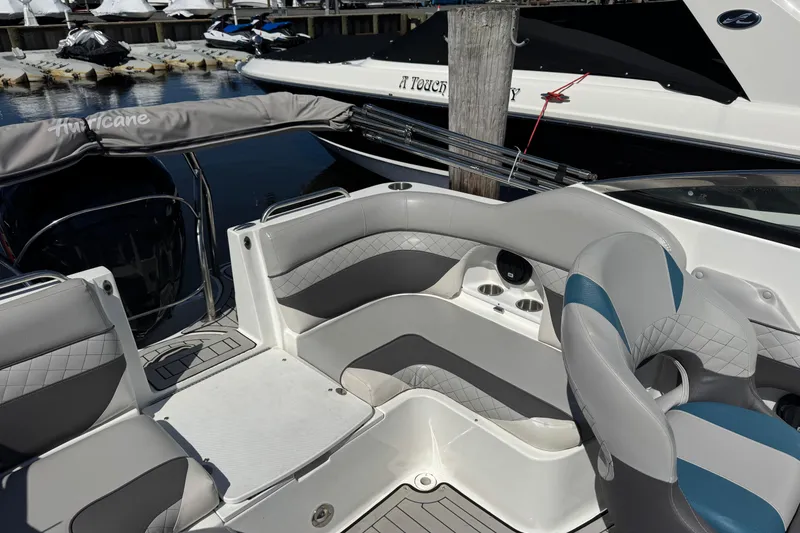 Slide: The Image of 2019 Hurricane SunDeck 2486 OB boat interior with gray seating and cup holders. - 8