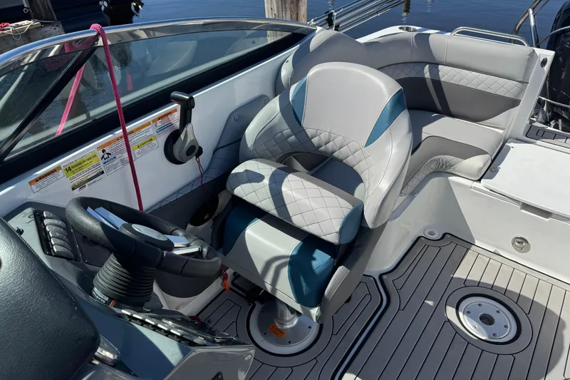Slide: The Image of 2019 Hurricane SunDeck 2486 OB boat interior with steering wheel and cushioned seating. - 9