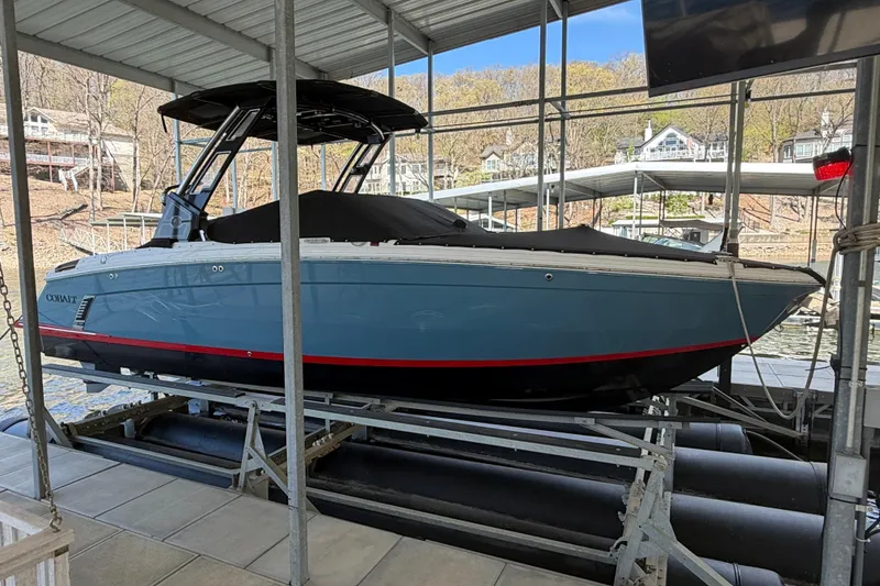 Slide: The Image of 2022 Cobalt R8 Surf boat docked in a covered marina, side view. - 12