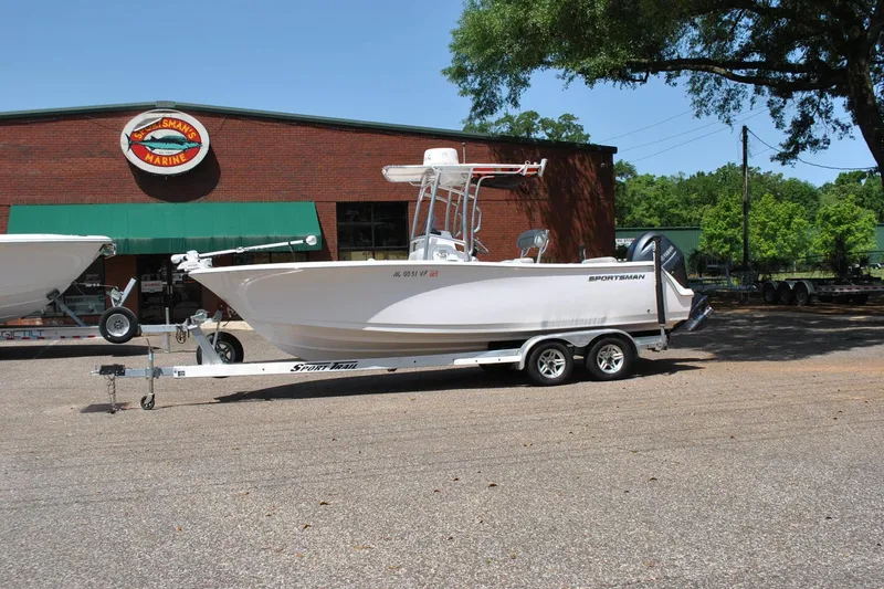 The Image of 2020 Sportsman Open 232 Center Console boat on trailer outside marine store. - 1