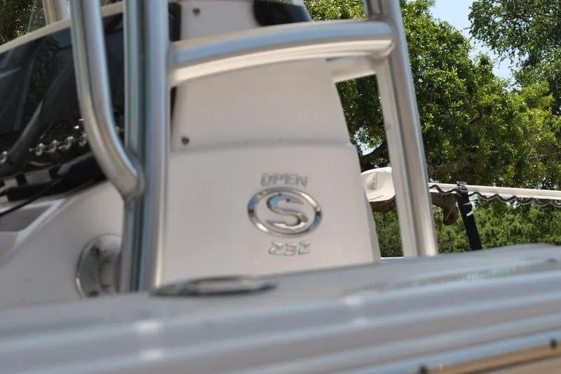 Slide: The Image of 2020 Sportsman Open 232 Center Console boat detail with logo, surrounded by greenery. - 11