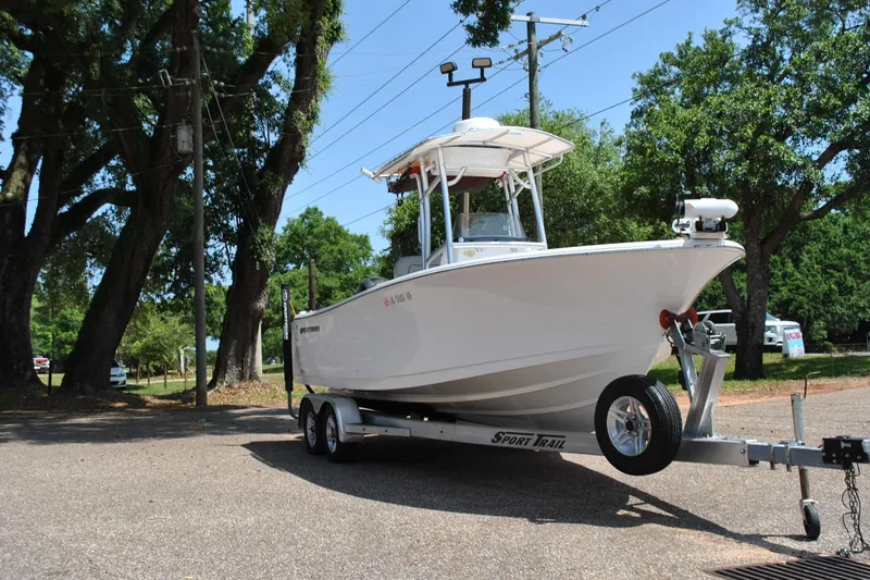 Slide: The Image of 2020 Sportsman Open 232 Center Console boat on trailer in a wooded area. - 3