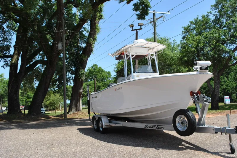 Slide: The Image of 2020 Sportsman Open 232 Center Console boat on trailer, parked under trees. - 4