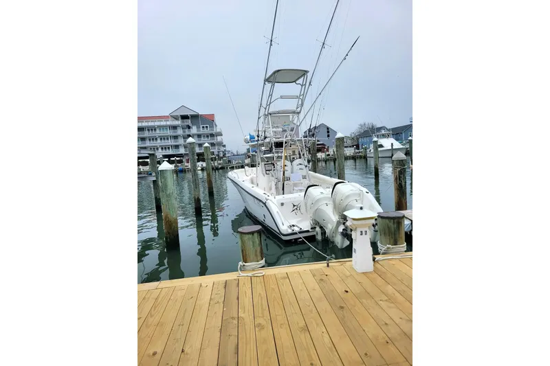 Slide: The Image of Century 3200 Center Console 2002 boat docked at marina with buildings in background. - 2