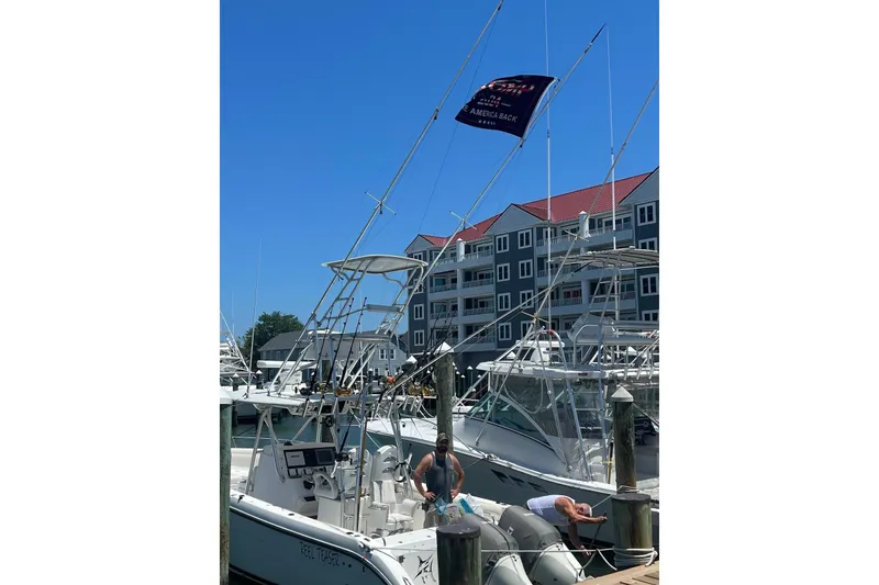 Slide: The Image of 2002 Century 3200 Center Console boat docked at marina with fishing gear. - 3