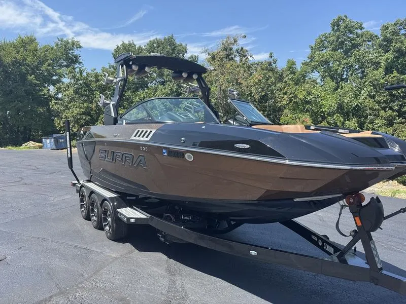 Slide: The Image of 2020 Supra 450 SE boat on trailer, parked outdoors, surrounded by trees. - 10