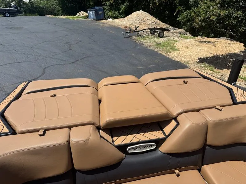 Slide: The Image of 2020 Supra 450 SE boat with tan leather seating, parked on asphalt near trees. - 16