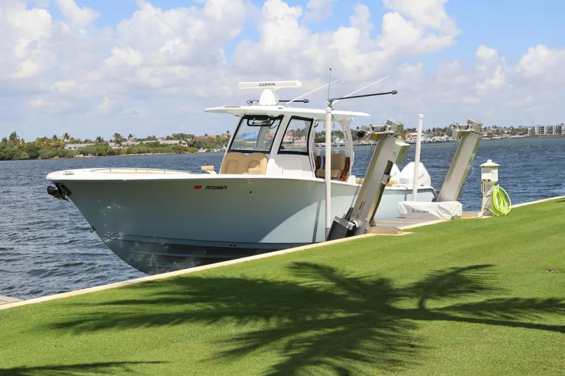 The Image of 2025 Sportsman Open 322 Center Console boat docked by a scenic waterfront. - 0