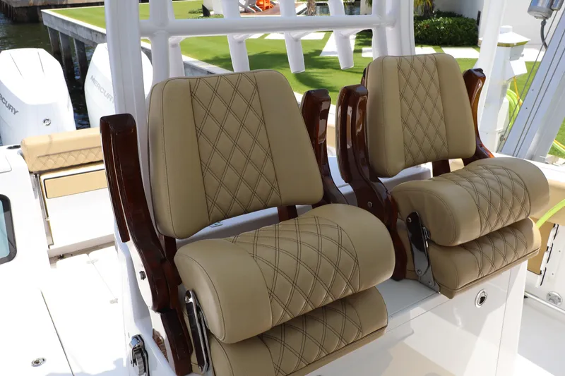 Slide: The Image of 2025 Sportsman Open 322 Center Console boat with luxurious tan seating and dual Mercury engines. - 13
