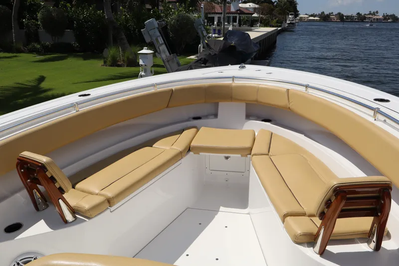 Slide: The Image of 2025 Sportsman Open 322 Center Console boat with tan seating, docked by a waterfront. - 3