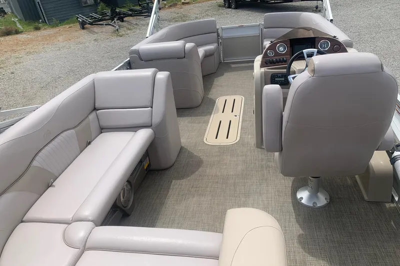 Slide: The Image of 2015 Avalon Windjammer Elite 25' boat interior with beige seating and steering console. - 11