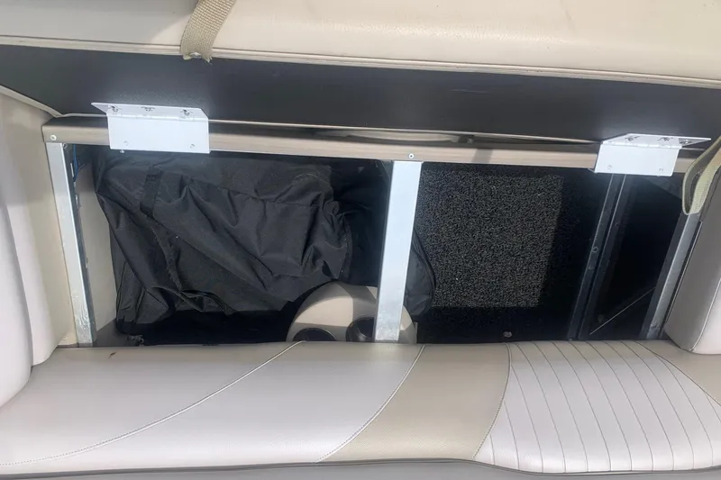 Slide: The Image of Interior storage compartment of 2015 Avalon Windjammer Elite 25' boat, featuring seating and storage space. - 18