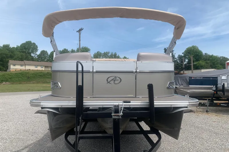 Slide: The Image of 2015 Avalon Windjammer Elite 25' pontoon boat with canopy, parked on a trailer. - 2