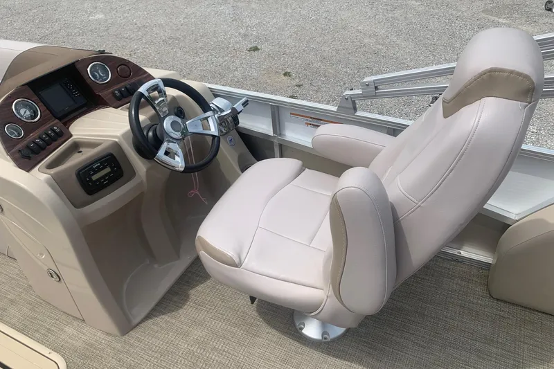 Slide: The Image of 2015 Avalon Windjammer Elite boat helm with plush captain's chair and modern dashboard controls. - 8