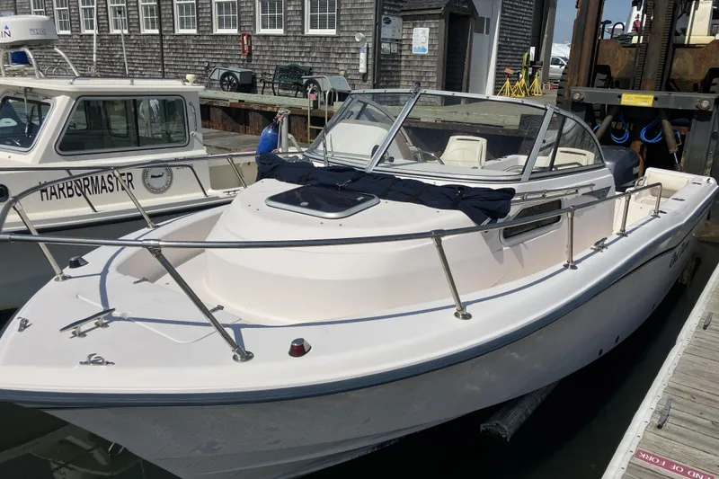 The Image of 1998 Grady-White Seafarer 226 boat docked at marina, alongside Harbormaster vessel. - 1