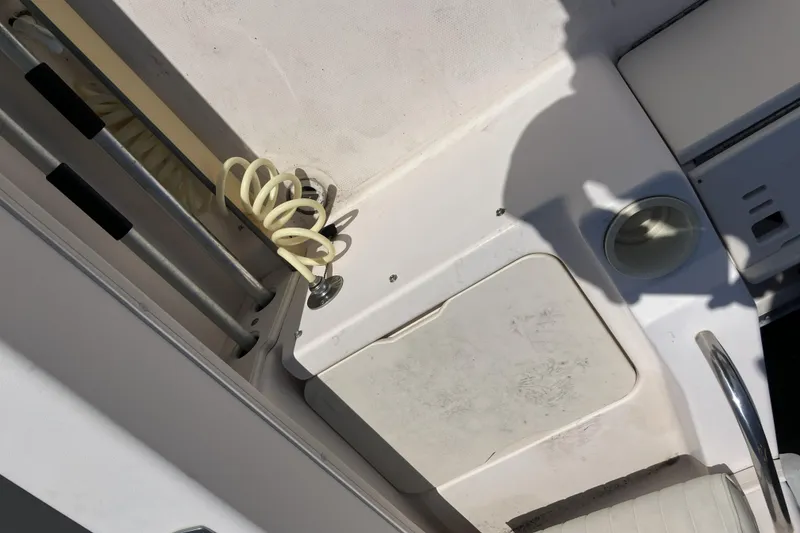 Slide: The Image of 1998 Grady-White Seafarer 226 boat deck with coiled hose and storage compartment. - 14