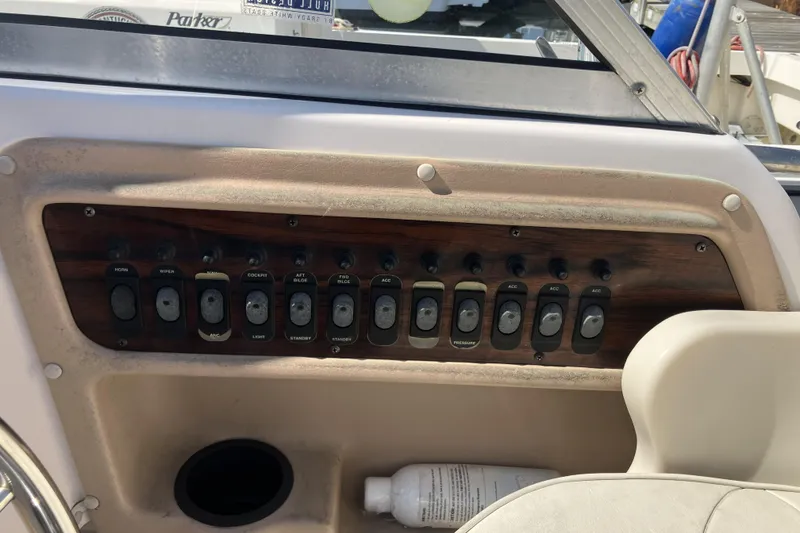 Slide: The Image of 1998 Grady-White Seafarer 226 dashboard with control switches and steering wheel. - 17
