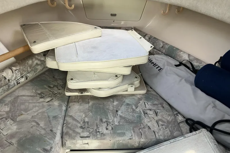 Slide: The Image of 1998 Grady-White Seafarer 226 cabin interior with stacked cushions and storage items. - 25