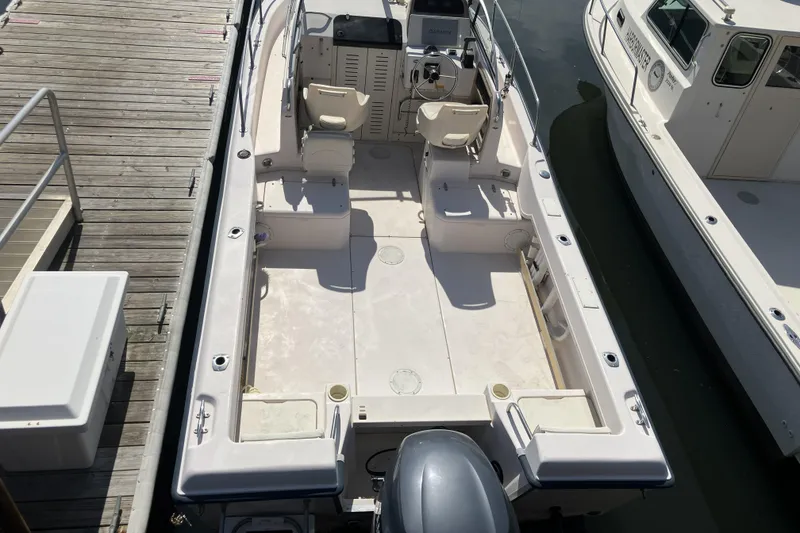 Slide: The Image of 1998 Grady-White Seafarer 226 boat docked, showcasing spacious deck and seating arrangement. - 3