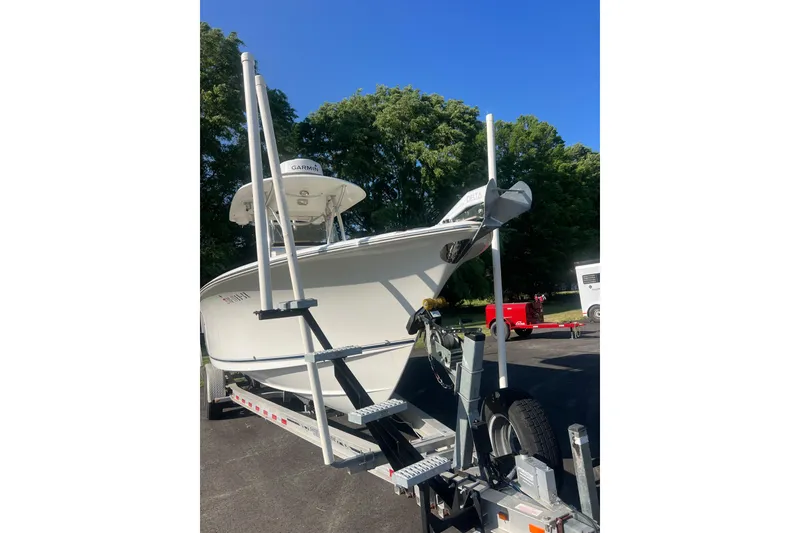 Slide: The Image of 2012 Sea Hunt Gamefish 27 boat on trailer, parked outdoors under clear blue sky. - 2