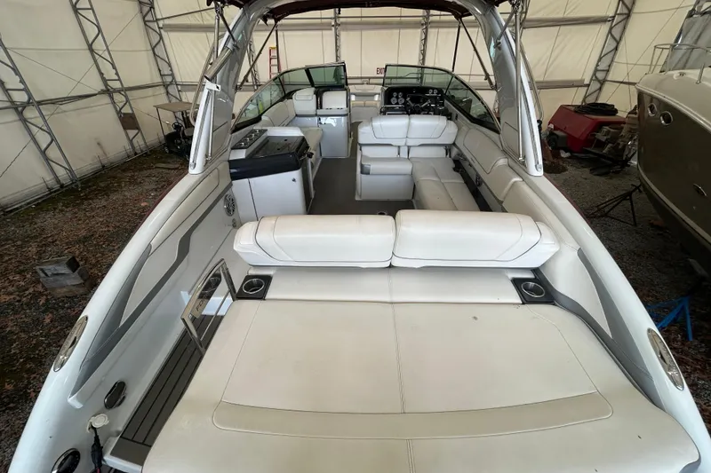 Slide: The Image of 2015 Formula 310 Bowrider interior with white seating, under a covered storage area. - 3