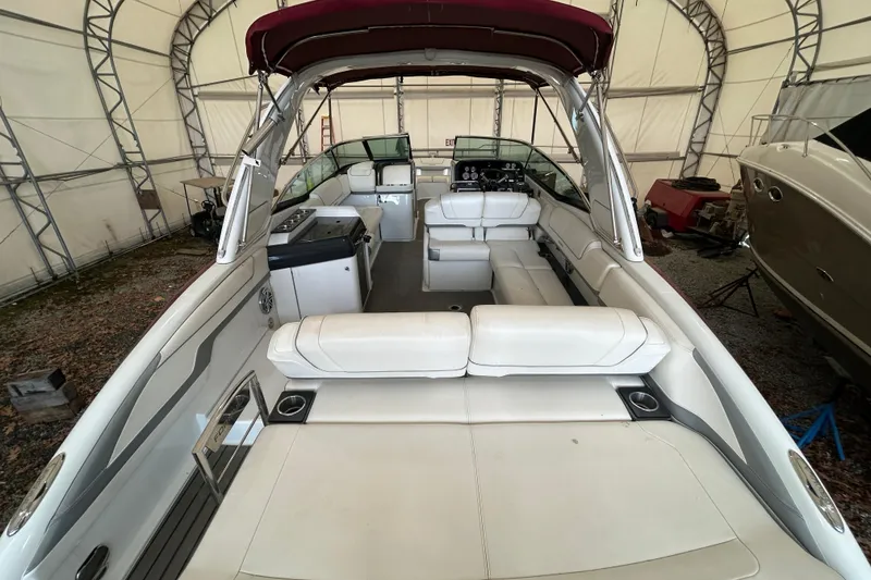 Slide: The Image of 2015 Formula 310 Bowrider with spacious white seating and maroon canopy in storage. - 4