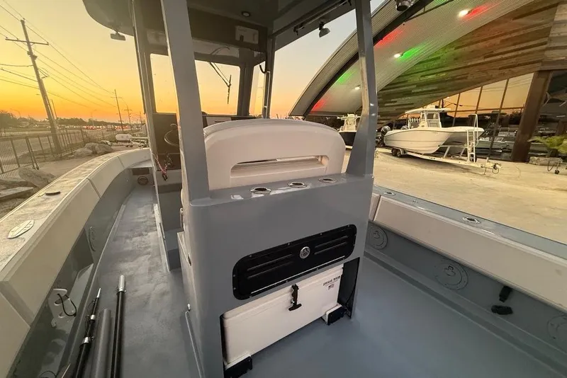 Slide: The Image of 2019 Metal Shark 28 CC boat interior at sunset, showcasing helm and seating area. - 13