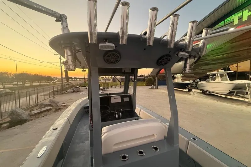 Slide: The Image of 2019 Metal Shark 28 CC boat interior at sunset, showcasing helm and rod holders. - 14