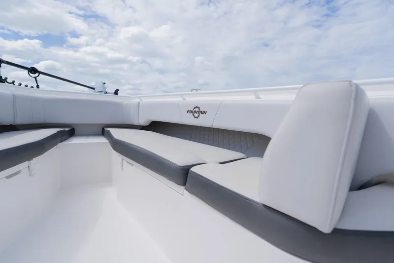 Slide: The Image of 2021 Fountain 38 Center Console boat interior with cushioned seating under a cloudy sky. - 13