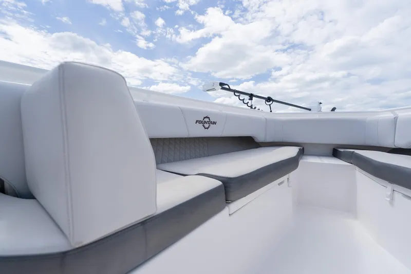 Slide: The Image of 2021 Fountain 38 Center Console boat interior with cushioned seating under a cloudy sky. - 14
