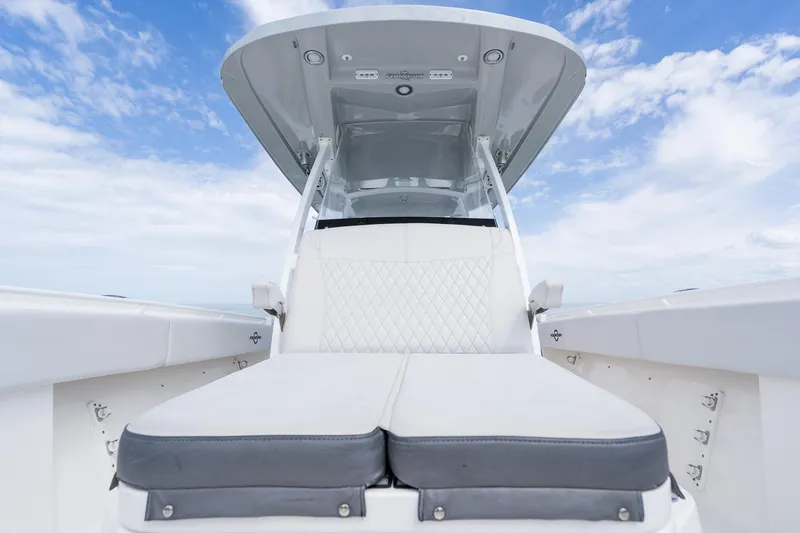 Slide: The Image of 2021 Fountain 38 Center Console boat interior with cushioned seating under blue sky. - 21