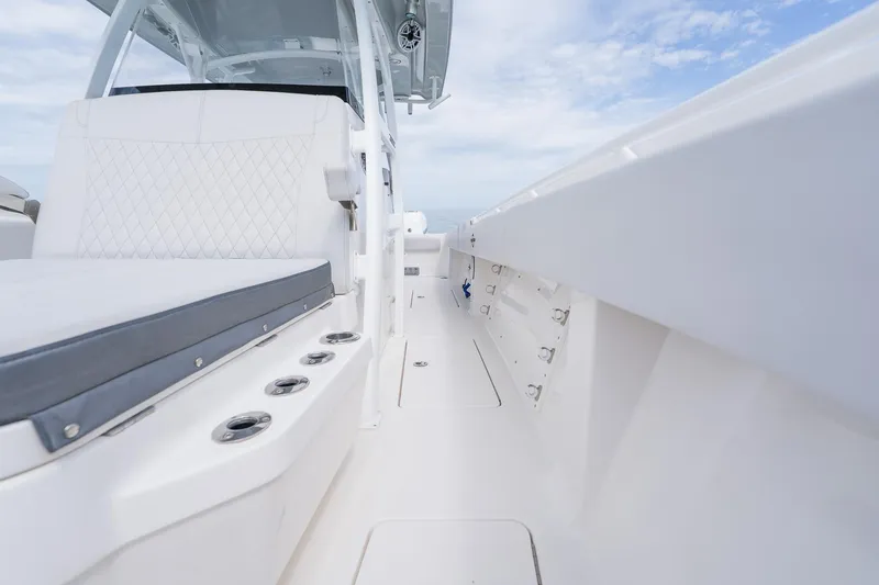 Slide: The Image of 2021 Fountain 38 Center Console boat interior with white seating and rod holders. - 26