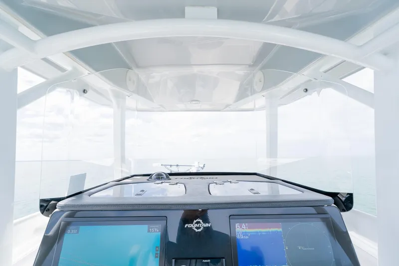 Slide: The Image of 2021 Fountain 38 Center Console boat dashboard with navigation screens and ocean view. - 34