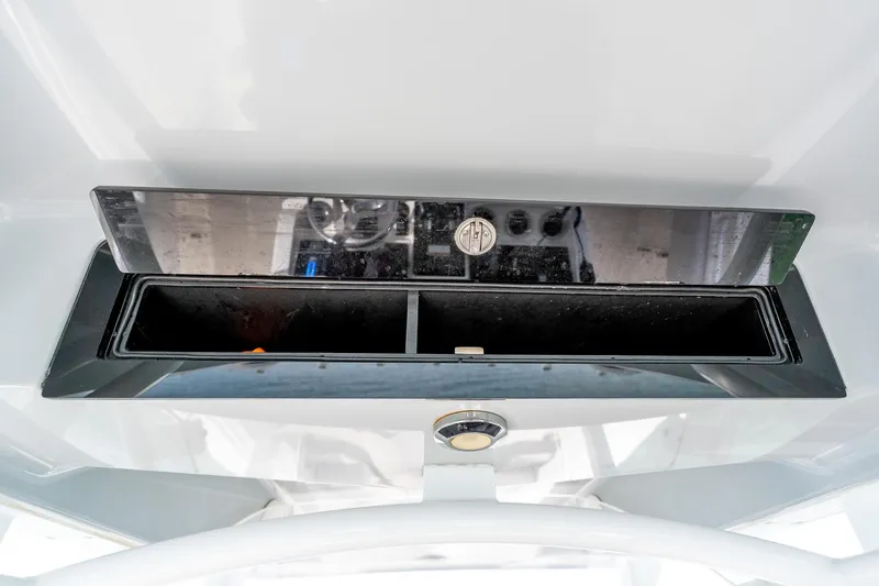 Slide: The Image of 2021 Fountain 38 Center Console dashboard compartment with reflective cover and storage space. - 36