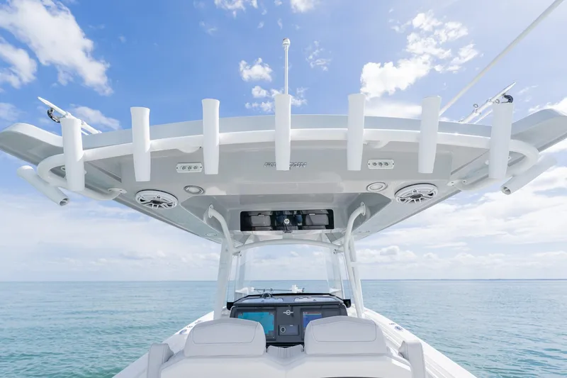 Slide: The Image of 2021 Fountain 38 Center Console boat, ocean view, clear sky, rod holders, and helm station. - 40