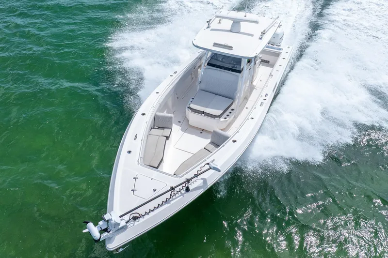 Slide: The Image of 2021 Fountain 38 Center Console boat cruising on clear green water. - 8