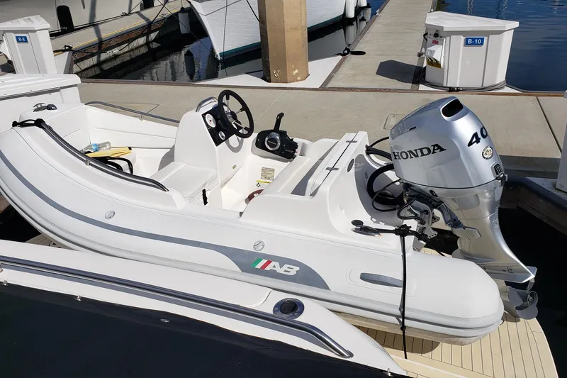 Slide: The Image of Inflatable boat with Honda 40 outboard motor docked beside Sea Ray 550 Sundancer, 2004 model. - 102
