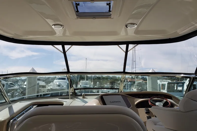 Slide: The Image of Interior view of 2004 Sea Ray 550 Sundancer yacht cockpit with marina backdrop. - 13