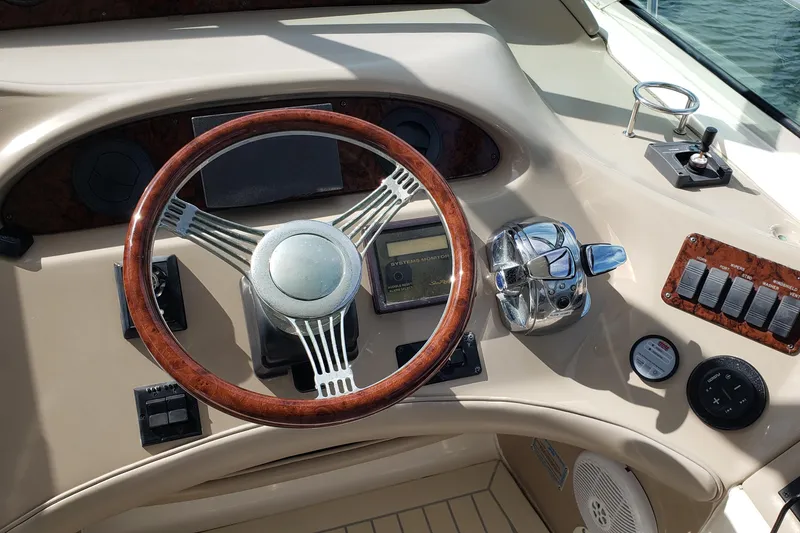 Slide: The Image of 2004 Sea Ray 550 Sundancer helm with wood-accented steering wheel and control panel. - 18