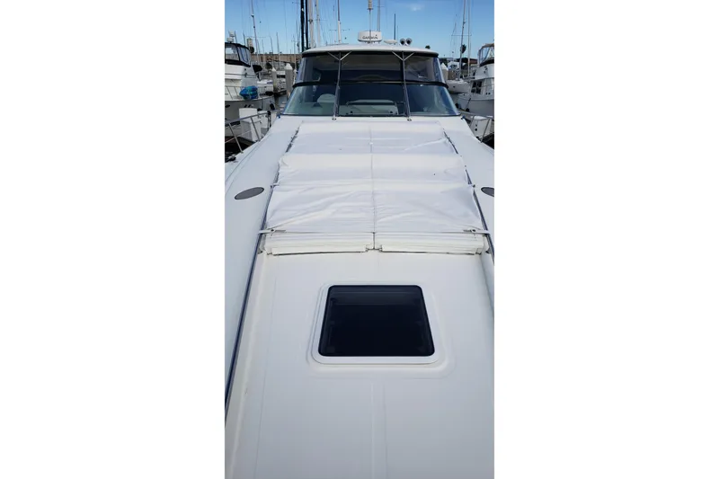 Slide: The Image of 2004 Sea Ray 550 Sundancer yacht docked in marina, showcasing sleek deck design. - 44