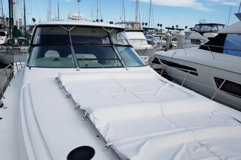 Slide: The Image of 2004 Sea Ray 550 Sundancer yacht docked in a marina, surrounded by other boats. - 48