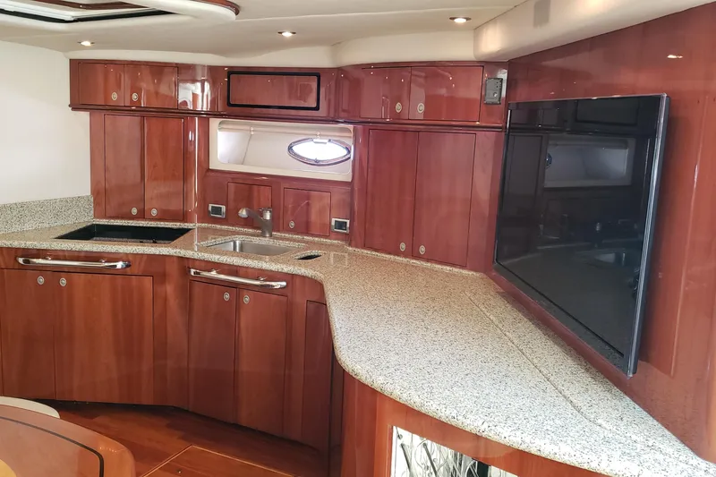 Slide: The Image of Luxurious 2004 Sea Ray 550 Sundancer yacht interior with sleek wooden cabinetry and modern amenities. - 56