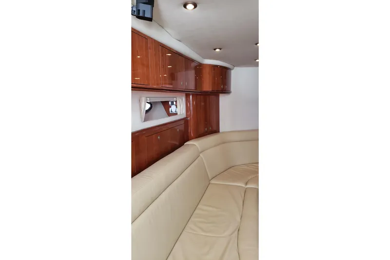 Slide: The Image of Interior of 2004 Sea Ray 550 Sundancer with beige leather seating and wooden cabinets. - 61