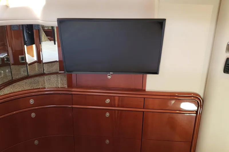 Slide: The Image of Interior of 2004 Sea Ray 550 Sundancer with mounted TV and wooden cabinetry. - 82