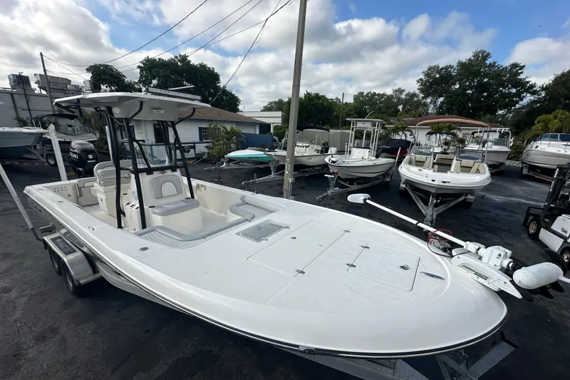 Slide: The Image of 2018 Sea Born FX25 Bay boat on trailer in a marina setting. - 12