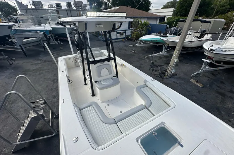 Slide: The Image of 2018 Sea Born FX25 Bay boat with T-top and seating, displayed in a marina. - 17