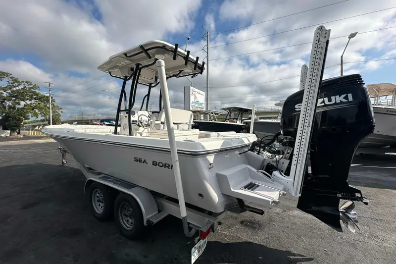 Slide: The Image of 2018 Sea Born FX25 Bay boat with Suzuki engine on trailer, parked outdoors. - 2
