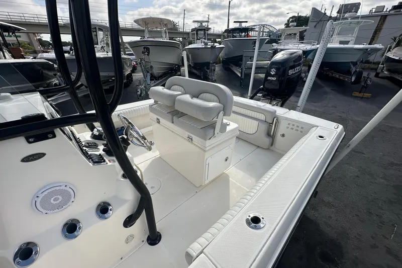 Slide: The Image of 2018 Sea Born FX25 Bay boat interior with seating and controls, docked with other boats. - 29
